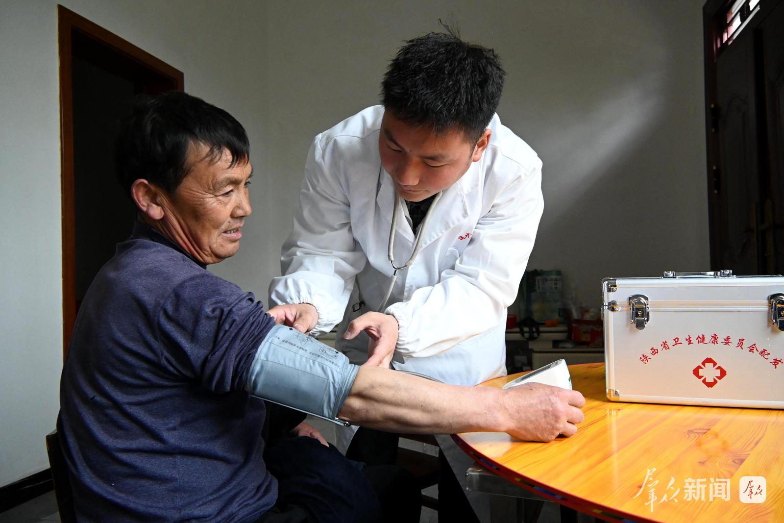 3月19日,安康市汉滨区流水镇良田村大学生村医入户为当地群众看病。