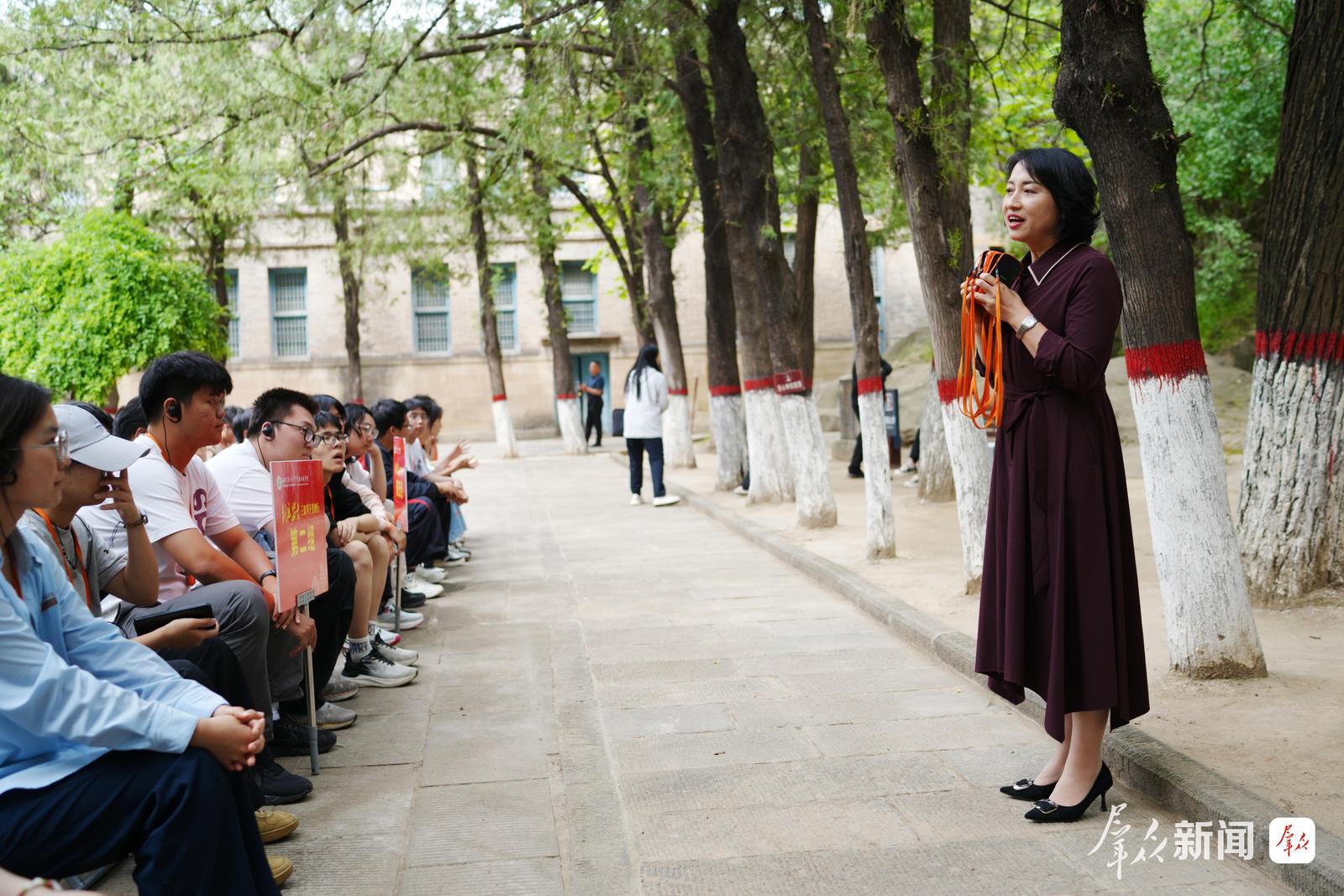 西北农林科技大学学生在杨家岭革命旧址聆听讲解员讲述红色历史。